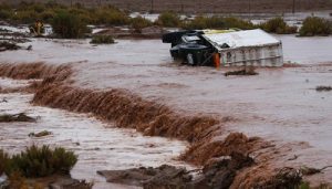 Caminhão de apoio tombado em estrada inundada