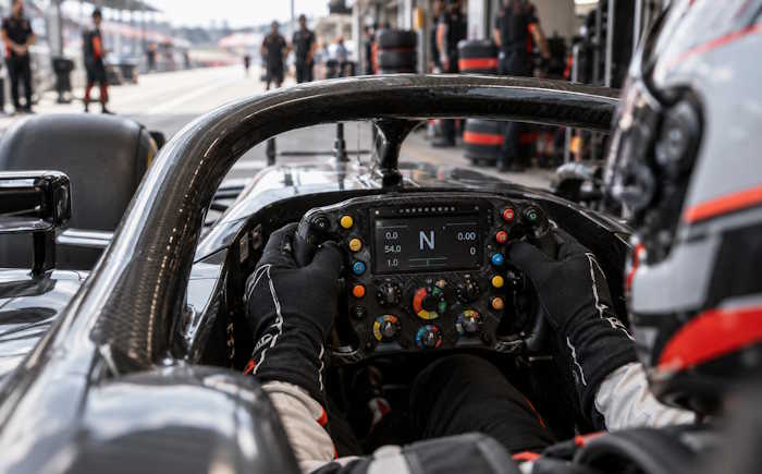 Piloto de Fórmula 1 controlando os seletores do volante no cockpit