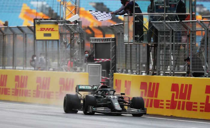 Lewis Hamilton cruza a linha de chegada com sua Mercedes em pista molhada no GP da Turquia de 2020.