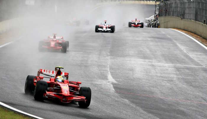 Felipe Massa lidera o pelotão com sua Ferrari no GP do Brasil de 2008, em Interlagos, com a pista molhada pela chuva.